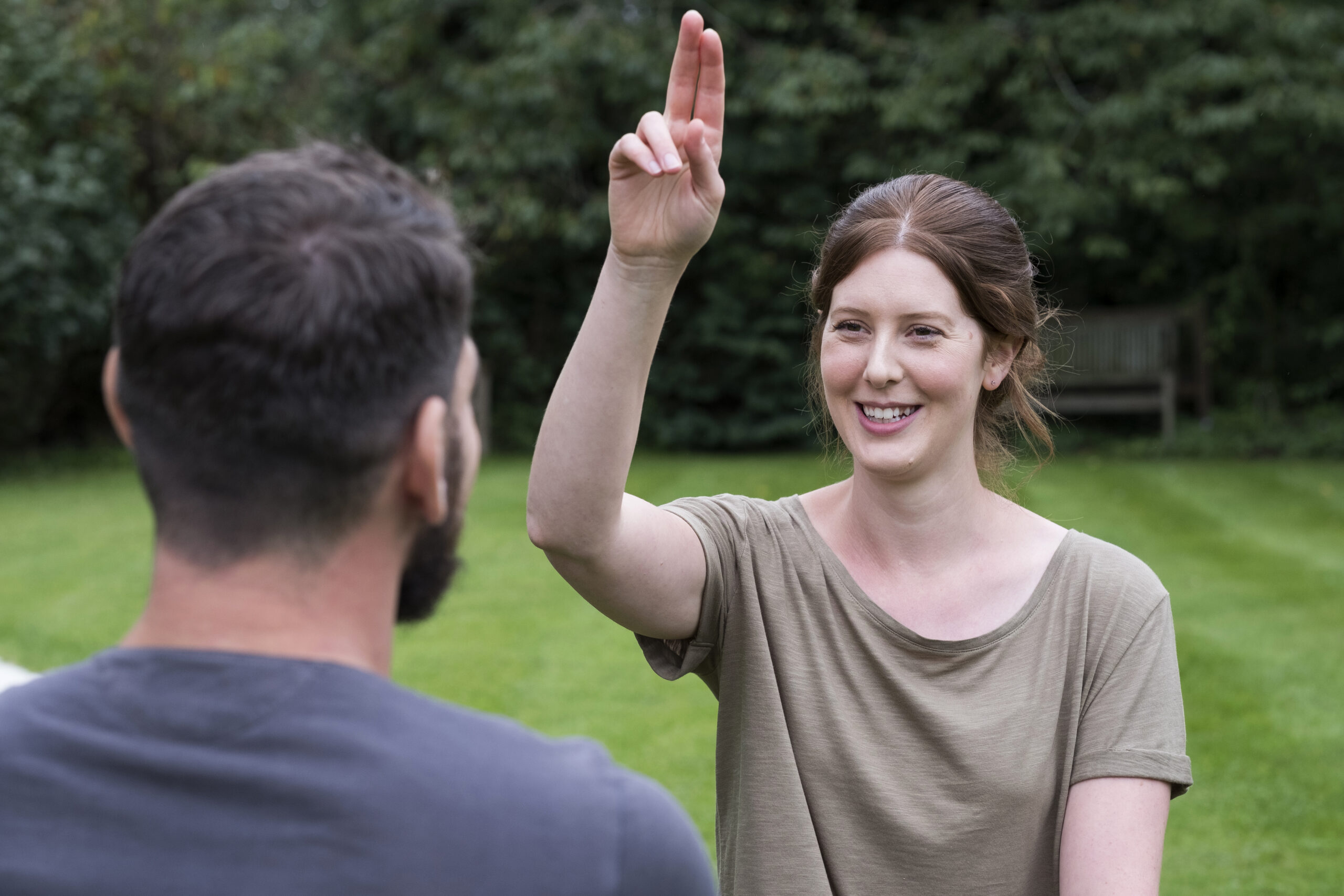 A woman using sign language (ASL) to communicate, illustrating the importance of scheduled interpreting services.